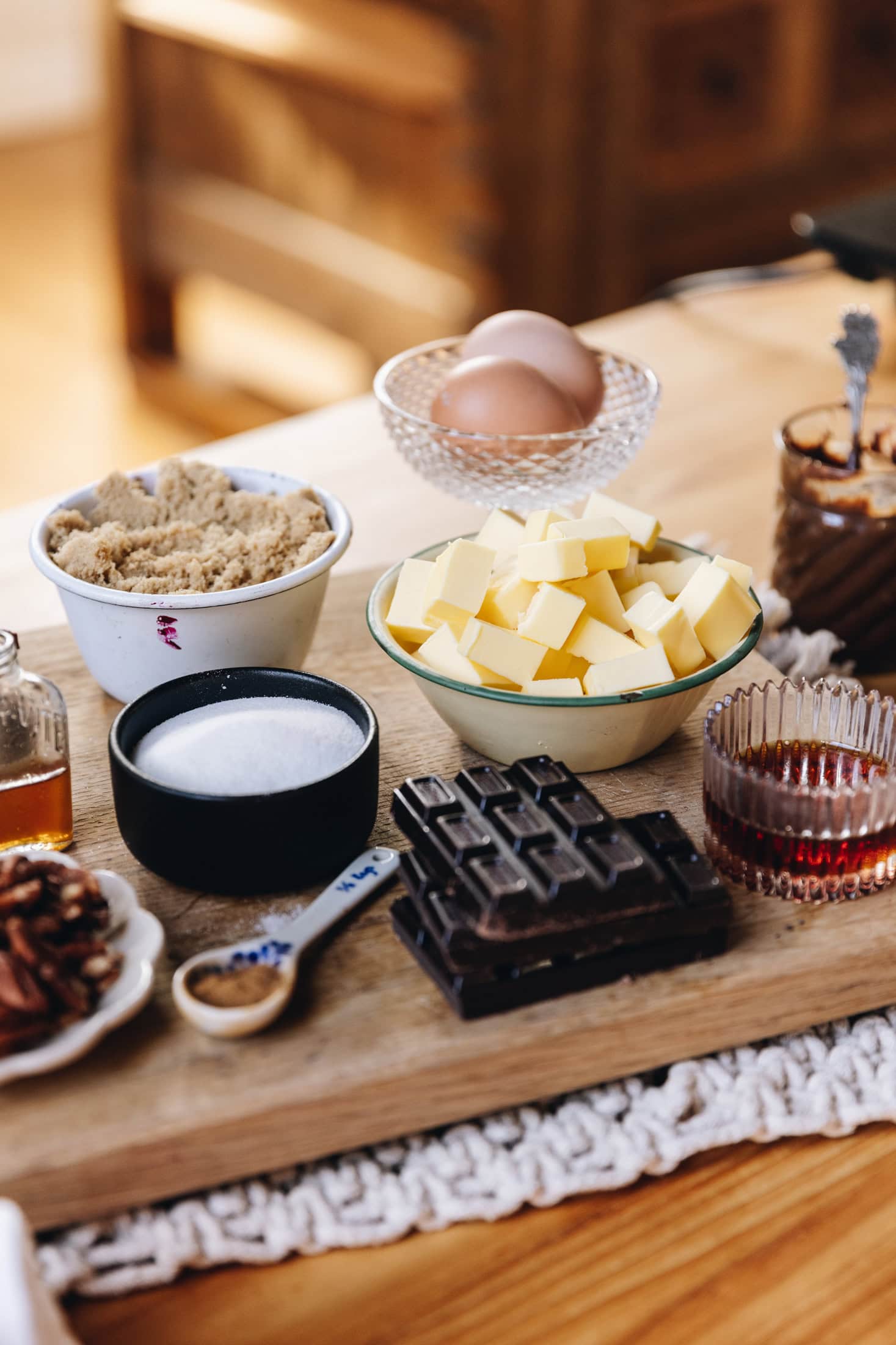 Gooey cookie pie ingredients are laid out on vintage cups, bowls and cups on a wooden board.