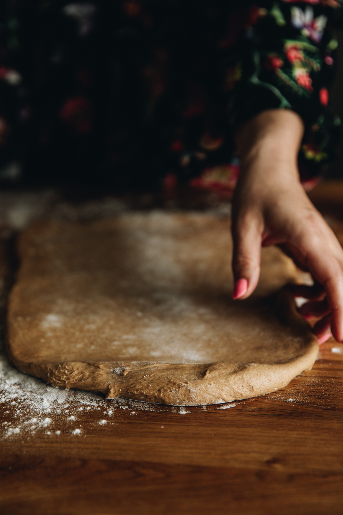 On a floured table is the gingerbread scroll spiced dough that has been rolled out. 