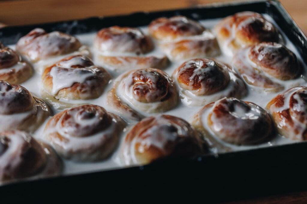 Landscape shot - coconut buns in coconut sauce in black tray.