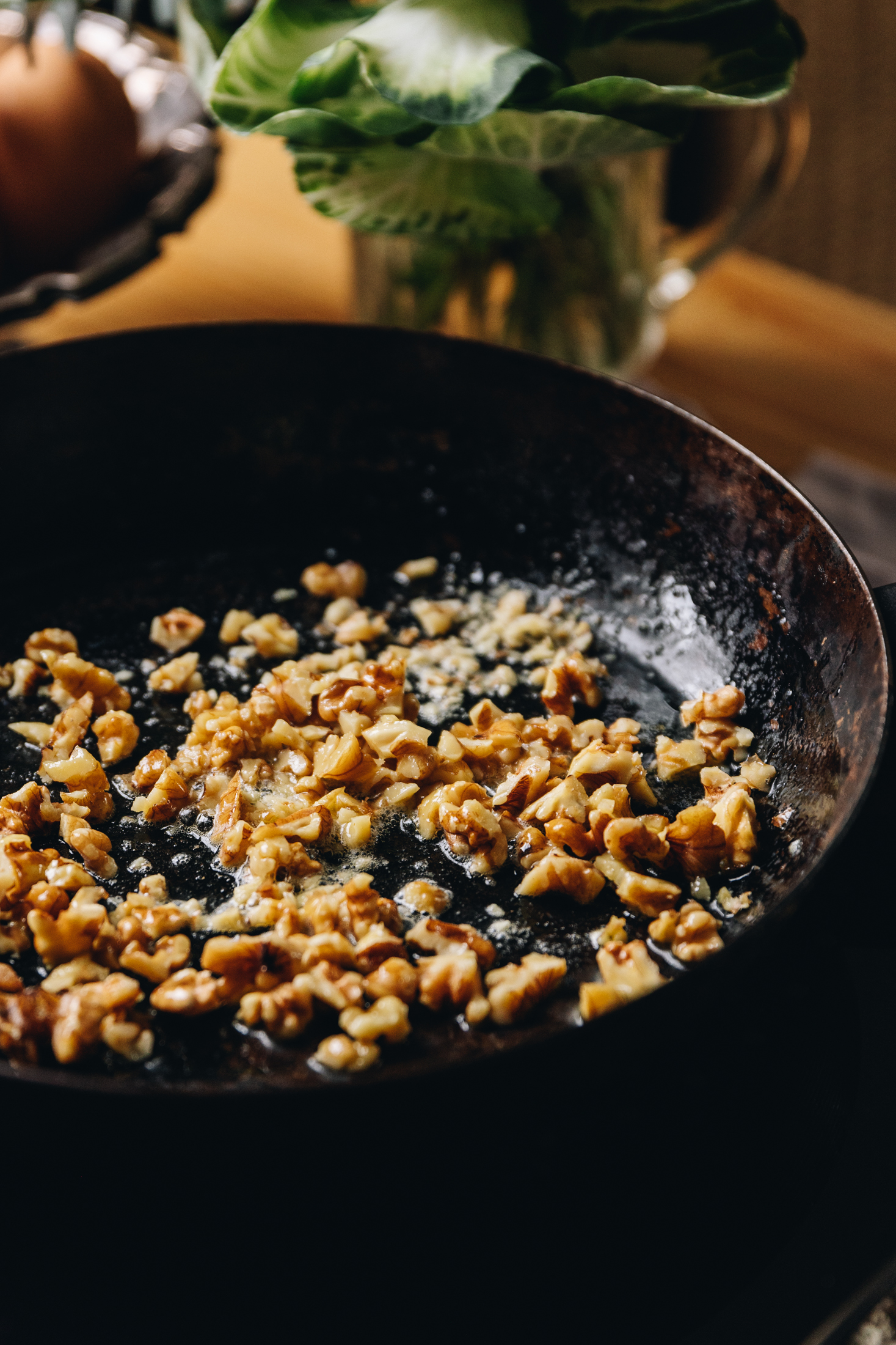 Toasted walnuts in a black cast iron pan. 