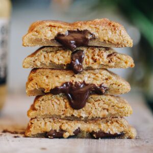 Five peanut butter stuffed cookies with chocolate oozing out.
