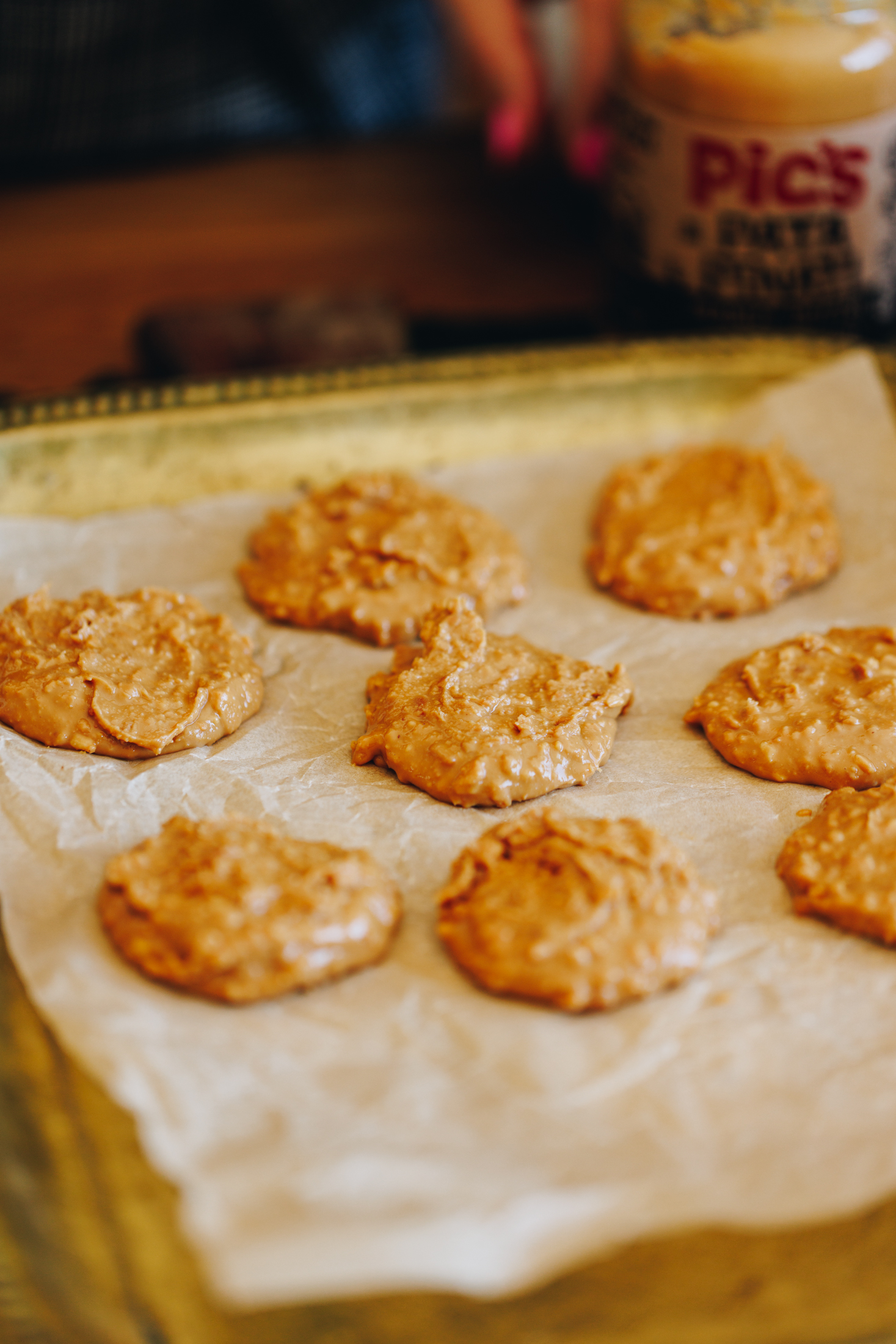 Peanut butter blobs on a gold tray, lined with baking paper.