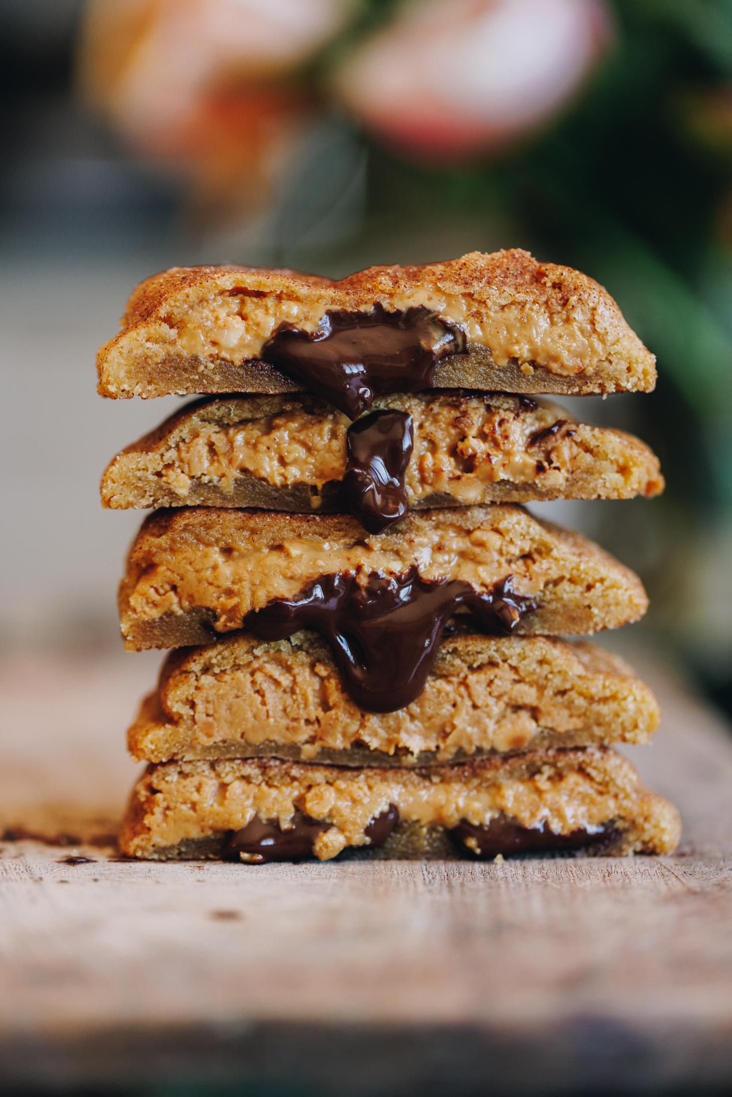 Five peanut butter stuffed cookies with chocolate oozing out. 